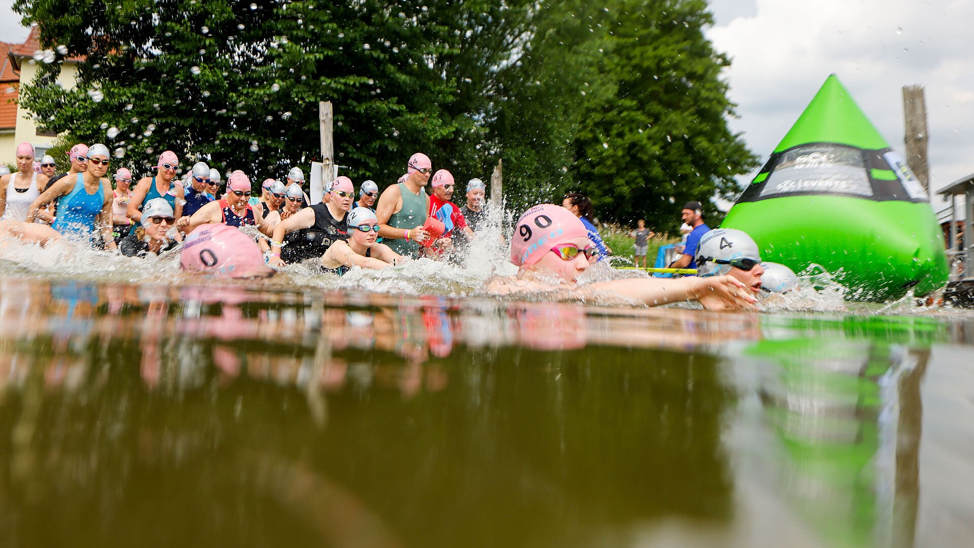 SwimRun: Teilnehmerfeld steigt ins Wasser und passiert eine grüne Boje © SCC EVENTS / Jean-Marc Wiesner 